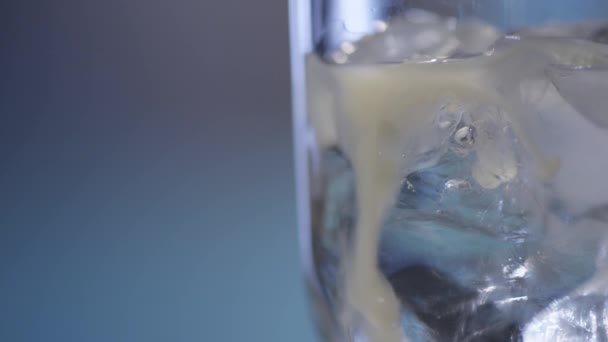 Water pouring over ice in glass — Stock Video