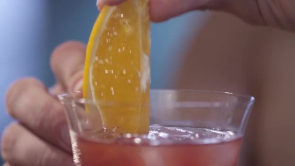 Добавление апельсина к коктейлю — стоковое видео