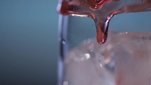 Röd sirap hälla över isen i glas — Stockvideo