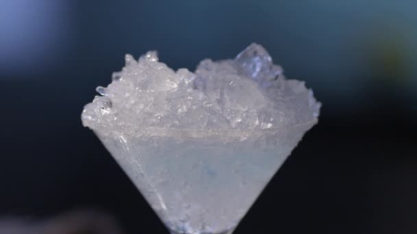 Giet een vloeistof op ijs in een Martini glas — Stockvideo