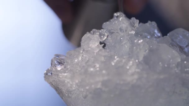 Gießen einer Flüssigkeit auf Eis in einem Martini-Glas — Stockvideo