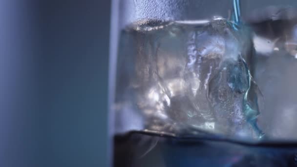 Nahaufnahme einer blauen Flüssigkeit, die auf Eis fließt — Stockvideo