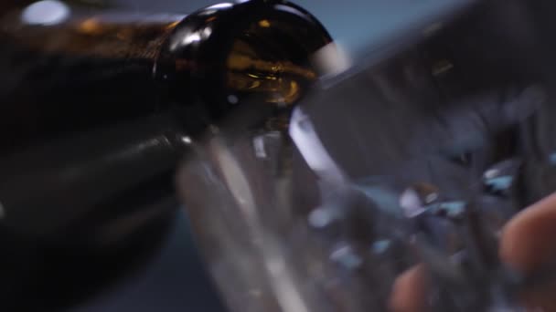 Nahaufnahme von Bier, das aus der Flasche in ein Glas gegossen wird — Stockvideo