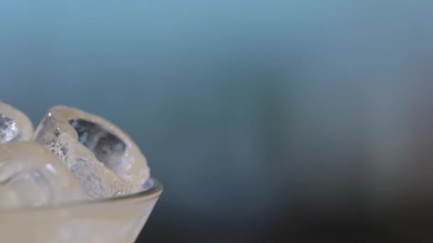 Close-up van geel cocktail met een limoen en ijs — Stockvideo