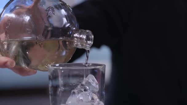 Líquido que fluye sobre hielo en un vaso — Vídeo de stock