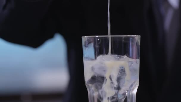 Weiße Flüssigkeit zu einem Cocktail hinzufügen — Stockvideo