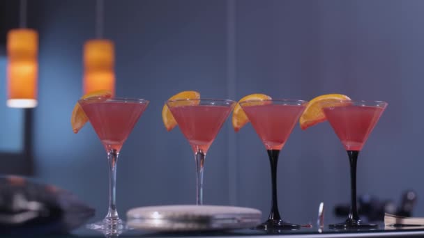 Vier kosmopolitische Cocktails an einer Bar — Stockvideo