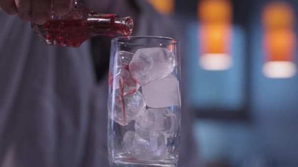 Siroop stroomt op ijs in een glas — Stockvideo