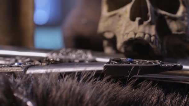 Espadas cadenas y cráneo en piel de oso — Vídeo de stock