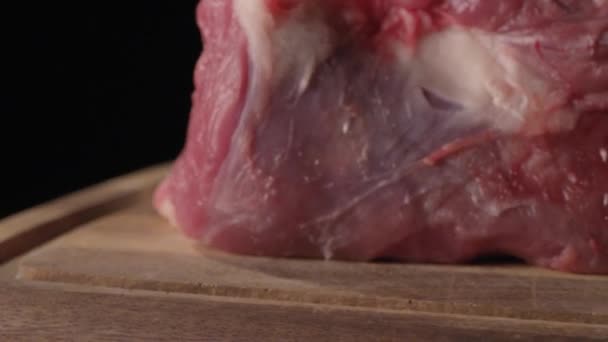 Meat on a cutting board with a black background — Stock Video