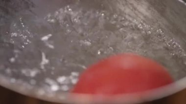 Bir tencerede kaynar su domates ekleme