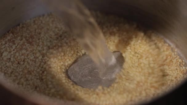 Ajouter de l'eau bouillante dans une casserole avec du grain — Video