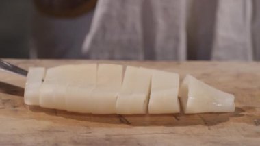 Bir kesme tahtası üzerinde Squid dilimlenmiş  