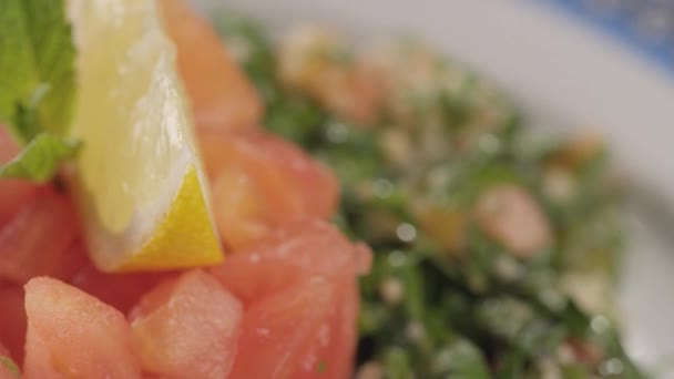 Γκρο πλαν, πράσινη σαλάτα με ένα κόκκινο ψάρι σε ένα πιάτο στροφής — Αρχείο Βίντεο