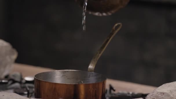 Ρίχνει νερό από μια καράφα σε μια κατσαρόλα — Αρχείο Βίντεο