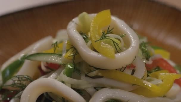 Close-up of salad with squid on a dish turning — Stock Video