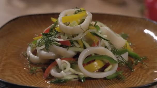 Салат с кальмарами на тарелке — стоковое видео