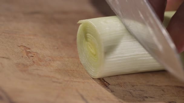 Fechar de alho-porro de corte em uma placa de corte — Vídeo de Stock