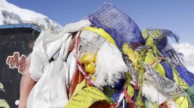 Nepal 'de bir Budist dua çarkının ve renkli dua bayraklarının sinematik 4K manzaralı çekimi. Tibet ruhani atmosferi, kutsal semboller, meditasyon, Himalayalar, ilahi ve huzurlu ruh hali..