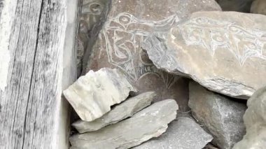 Nepal 'de bir Budist dua çarkının ve renkli dua bayraklarının sinematik 4K manzaralı çekimi. Tibet ruhani atmosferi, kutsal semboller, meditasyon, Himalayalar, ilahi ve huzurlu ruh hali..