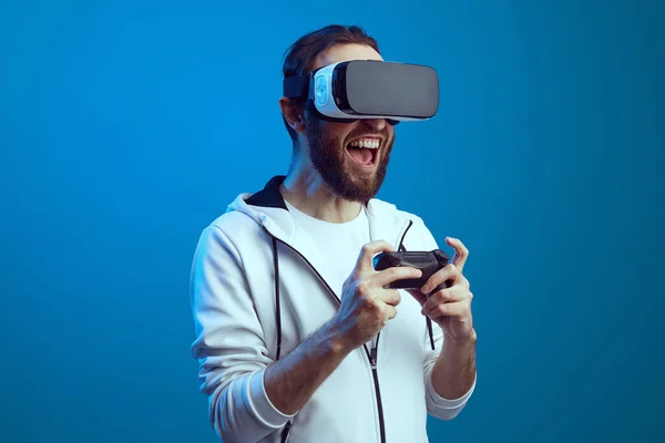 Young excited bearded man standing with the VR equipment and playing — Stock Photo, Image