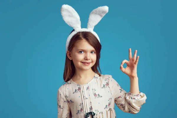 Cute teen girl wearing bunny ears and casual dress showing okay sign — Stock Photo, Image