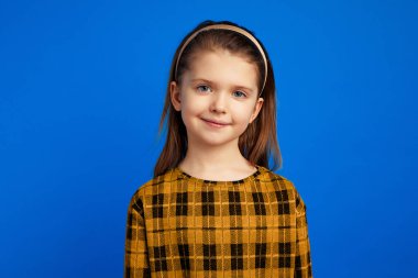 Kız huzur içinde ve mavi arka planda tek başına duruyor.