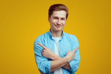 Gülümseyen adam ellerini göğsünün üzerinden geçirir, her iki tarafı gösterir, sağ ve sol.