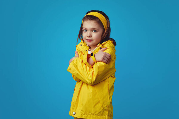 Dissatisfied girl smirks face, keeps arms crossed, trembles from being cold