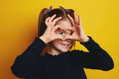 Güzel kız gülümsüyor ve kollarını tutuyor.