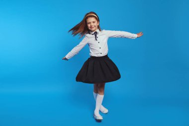 Okul üniforması içinde hızlı dönen tatlı bir kız, bu da onun parlamasına neden oluyor.