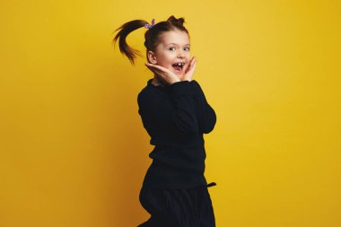 Şaşkın şirin çocuk avuçlarını aç ve atlarken çekici yüzünü göster.