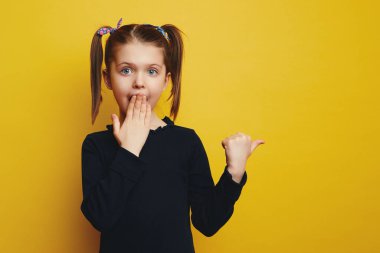 Etkileyici küçük şirin çocuk parmak boşluğunu gösterir, sessiz ağzı kapatır.