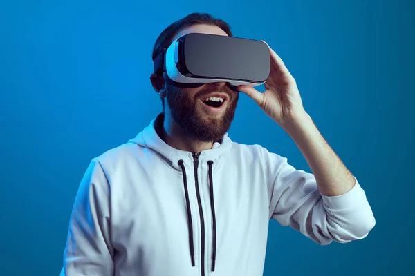 Homem alegre tendo a experiência VR e ajustando o fone de ouvido. — Fotografia de Stock