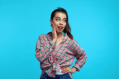 Kız elini beline koyuyor. Şaşırtıcı bir şekilde, şok edici haberlere tepki veriyor.