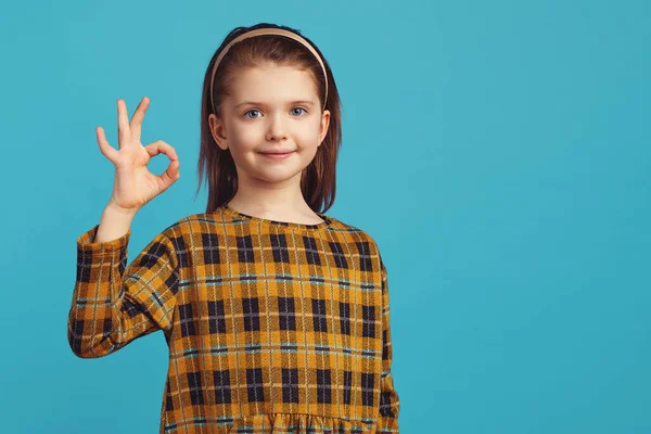Kid girl mostra sinal ok ou tudo bem gesto, recomenda um bom produto — Fotografia de Stock