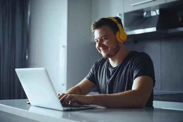 Smiling young man freelancer using laptop studying online working from home