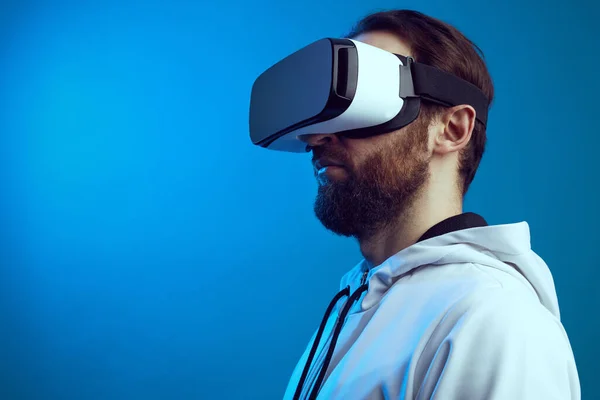 Side view of serious guy in VR headset experiencing another world in studio — Stock Photo, Image