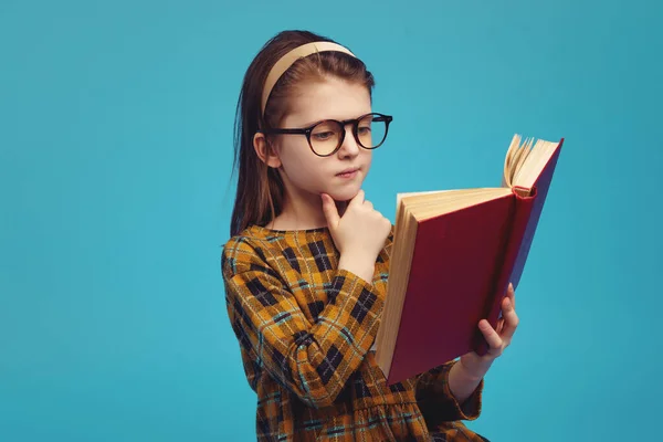 Estudante feliz em óculos lendo livro e fazendo lição de casa — Fotografia de Stock