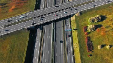 Otoyol Üstgeçidi Hava Trafik Lojistik Kavşağı. Hareket eden hava görüntüsü yoğun çoklu şeritli yol kavşağını gösteriyor S11 A2 pürüzsüz ulaşım akışı ve çevreleyen yeşil manzara