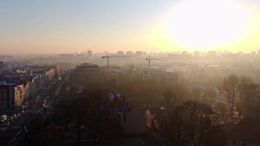 Gündoğumu şehri sisi inşaat vinçleri havadan. Golden Morning Light Kentsel Gelişim İkamet İdaresi modern mimari altyapı büyümesi yatırım sektörü Avrupa 'nın duman ufuk çizgisi genişlemesi Polonya' yı bünyesine katıyor