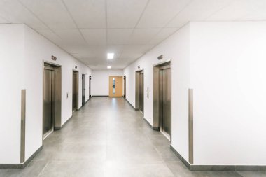 Ofis koridoru asansörleri modern iç perspektif. Kurumsal bina koridoru paslanmaz çelik kaldırma kapıları simetrik mimari temiz tasarım ticari mülkiyet iş yeri altyapısı iş ortamı