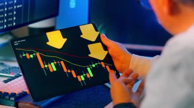 Tablet taşıyıcı şamdan tablosu aşağı doğru ok ticareti kaybı. Yatırımcı borsa arayüzünü analiz ediyor kırmızı eğilim çizgisi fiyatı dalgalanma riski daralması finansal kriz portföy baskısı