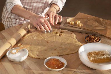 Bir kadın geleneksel yıldız şeklinde Noel bisküvileri pişiriyor.