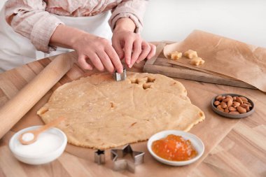 Bir kadın geleneksel yıldız şeklinde Noel bisküvileri pişiriyor.