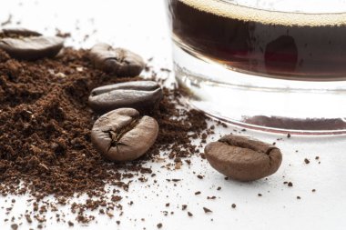 Kahve çekirdekleri, öğütülmüş kahve ve bir fincan yakın plan.