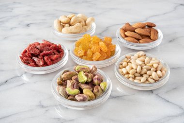 Cam tabakta çeşitli kurutulmuş tohumlar ve meyveler.