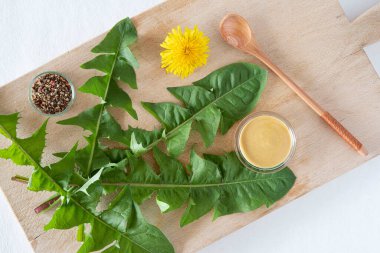 Karahindiba yaprakları ve salata sosu mutfakta.