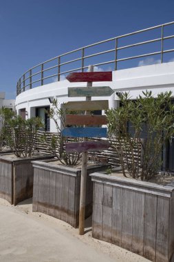 Bir binanın önündeki kumsalda yön işaretleri.