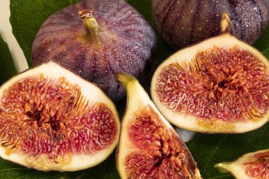 Dilimlenmiş incir yaprağına yakın çekim ve mor incir.